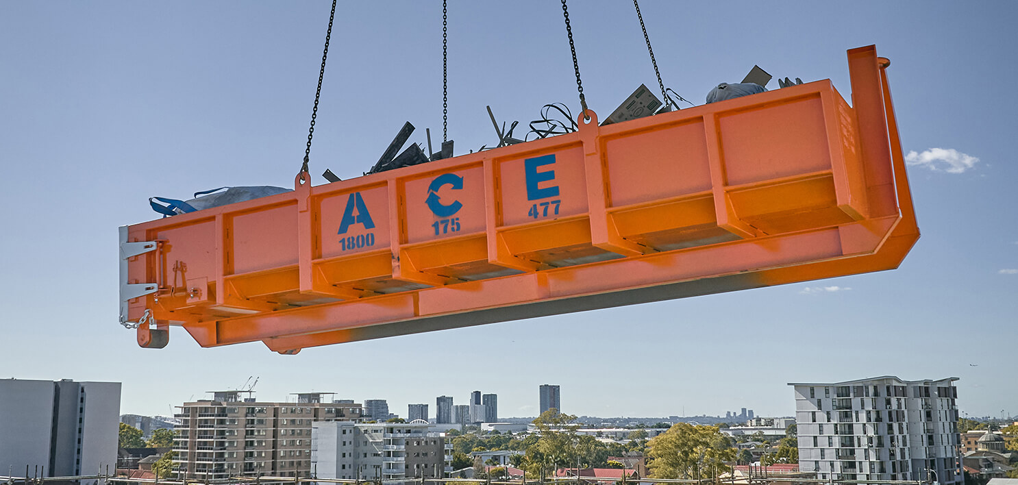 An ACE Skip Bin being held aloft by a crane
